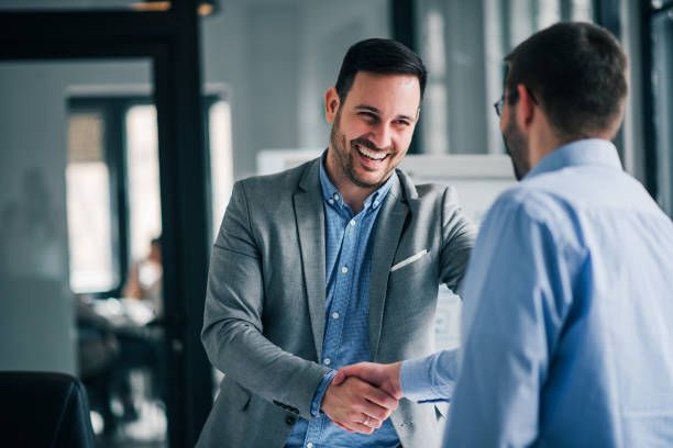 Two business owners shaking hands after a funding consultation